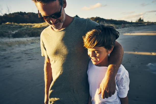 Father And Son Running Along Beach