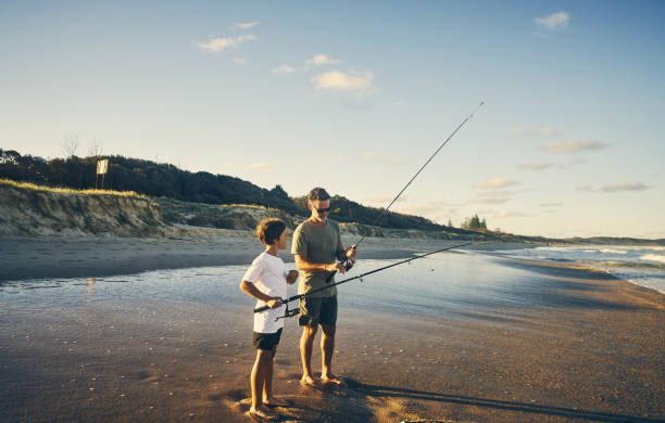 Rather teach them instead of just giving Shot of a father and son enjoying a day outdoors fishing stock pictures, royalty-free photos & images