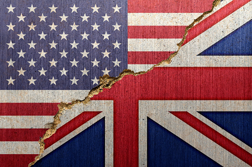 Flags of the United States of America (USA) and the United Kingdom (UK) on a cracked concrete background