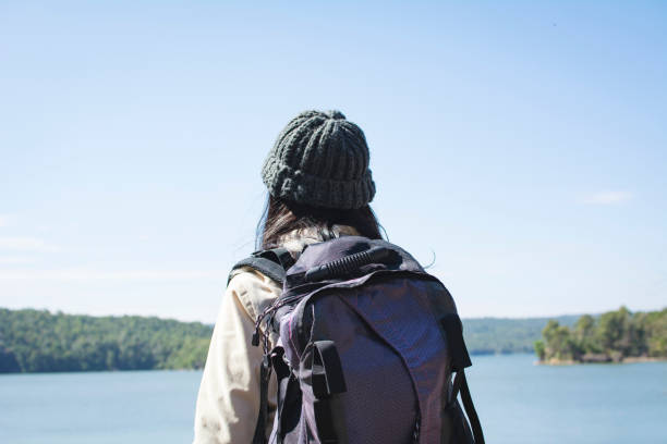 istock Rear View Of Backpack Woman Standing Against Lake 913043192