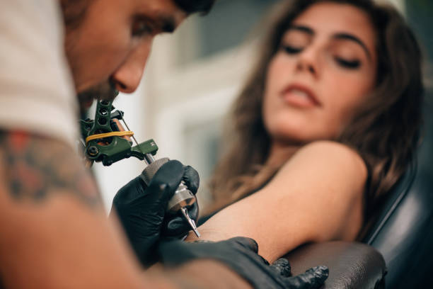 primer plano de mamá haciendo tatuaje en la mano de la mujer - tattoo machine fotografías e imágenes de stock