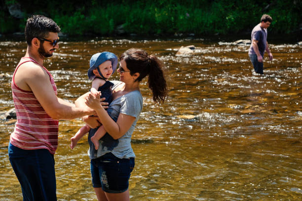 istock Millennial family bathing in a river in summer nature. 913055234