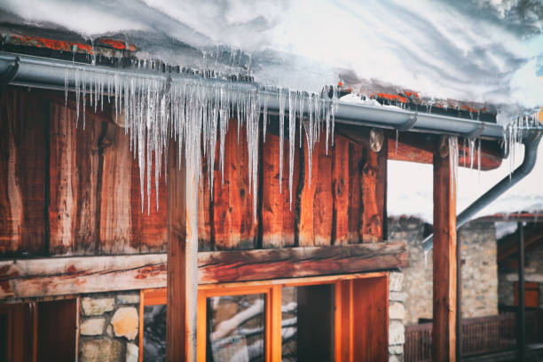 крупным планом замороженного балкона общего деревянного шале зимой со сталактитами и снегом - thick snow стоковые фото и изображения