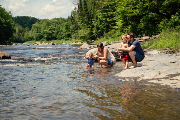 Millennial family bathing in a river in summer nature.