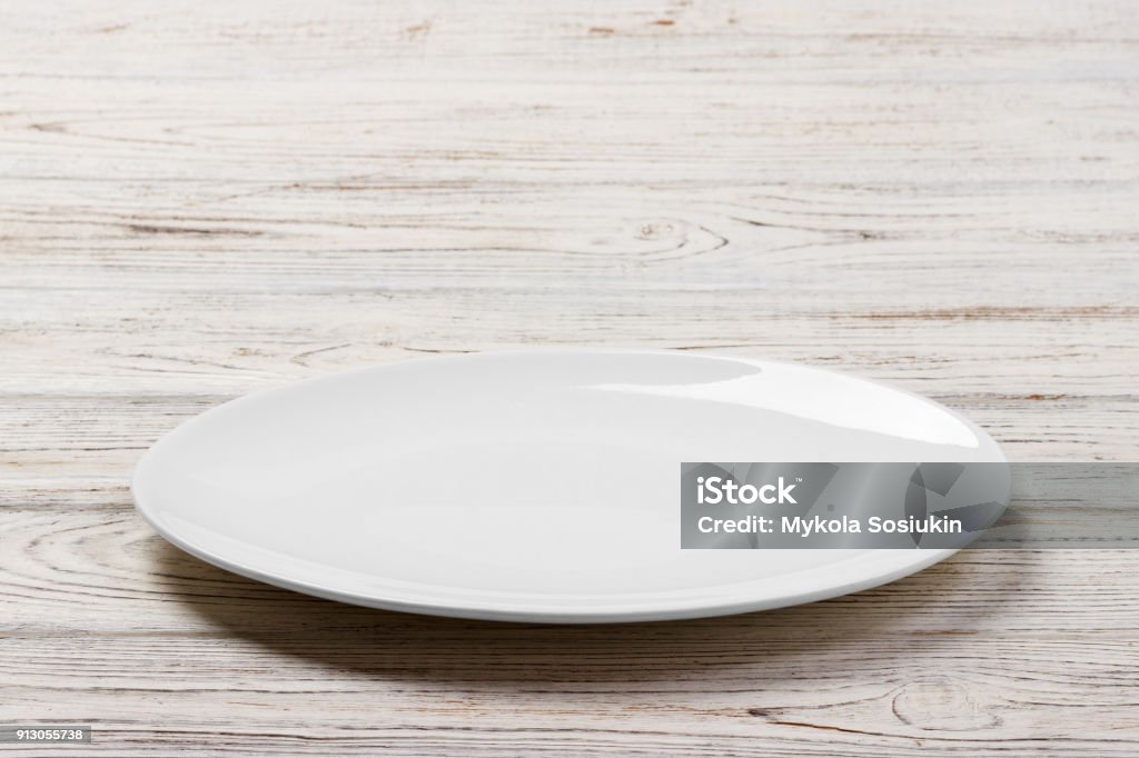 White Round Plate on white wooden table background. Perspective view White Round Plate on white wooden table background. Perspective view. Plate Stock Photo