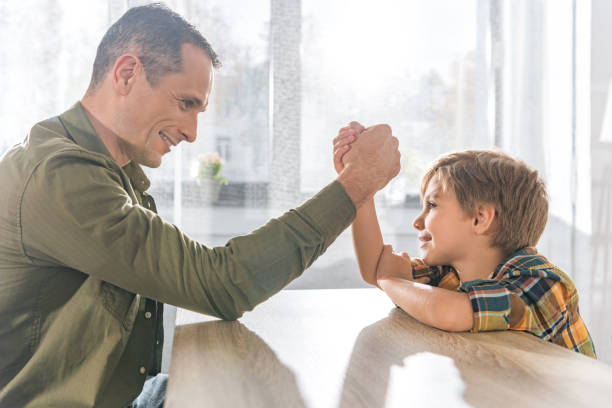 istock father and son arm wrestling together 913055782