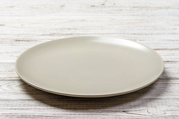 istock Perspective view. Empty white plate on wooden background 913055798