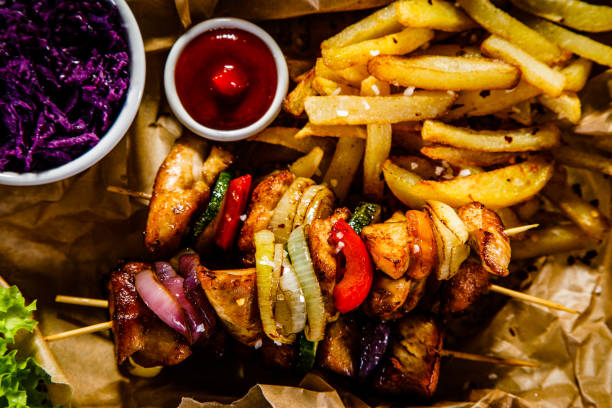 istock Kebabs - grilled meat and vegetables on wooden background 913055820