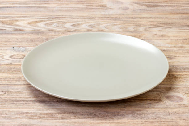 istock empty round plate for food on wood bachground. Perspective view 913055844