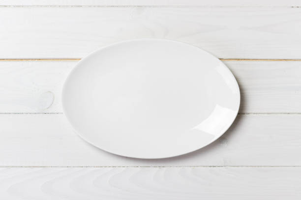 istock Top view of empty white food plate on a wood background 913055920
