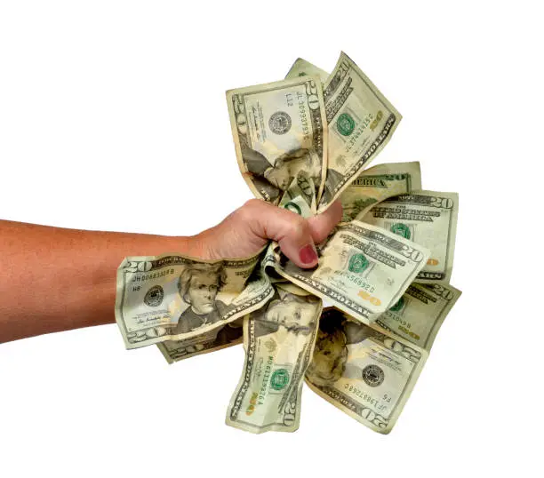 Horizontal shot of a woman's hand grasping a pile of twenty dollar bills.  White background.