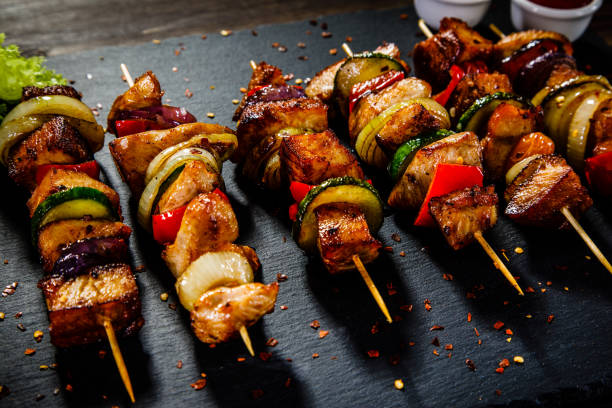 istock Kebabs - grilled meat and vegetables on wooden background 913058594