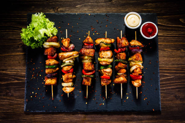 istock Kebabs - grilled meat and vegetables on wooden background 913058684
