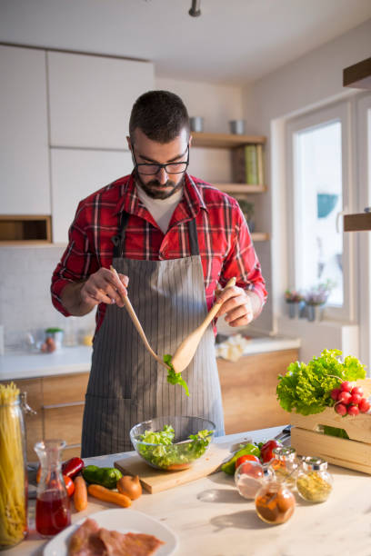 istock Man preparing vegetable salad at home 913058734