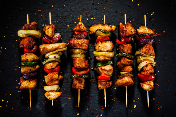 kebabs - gegrilltes fleisch und gemüse auf holzhintergrund - grillhühnchen stock-fotos und bilder