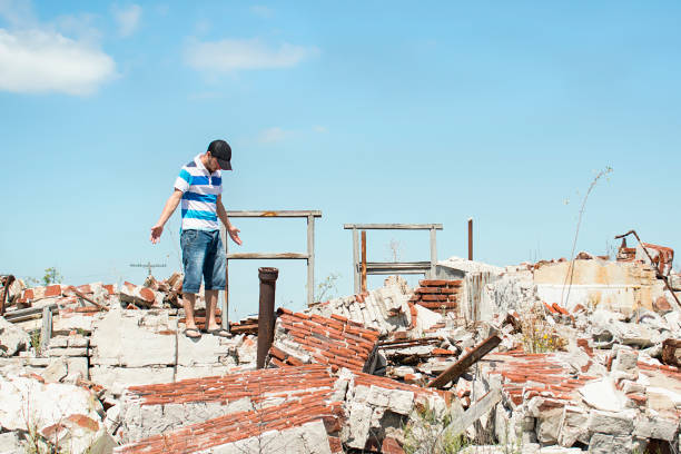 istock Man observing the destruction of his home. 913058976