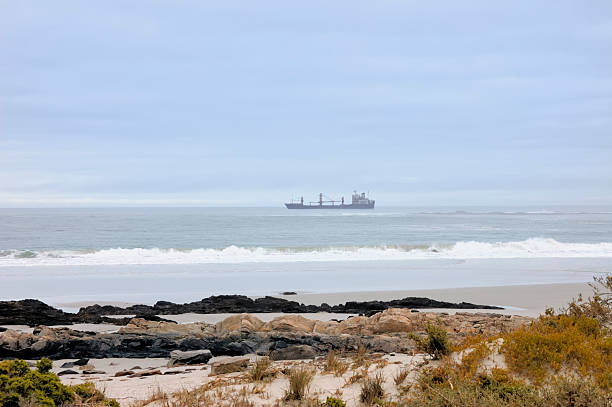 A ship rides at anchor in the Atlantic off the coast of South Africa at Port Noloth in the Orange river delta.