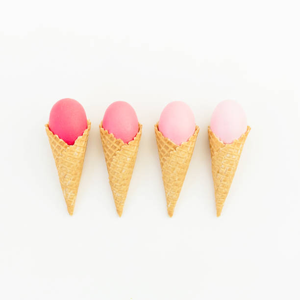 istock Pink Easter eggs in waffle cone on white background. Flat lay. Top view. Creative holiday concept. 913062370