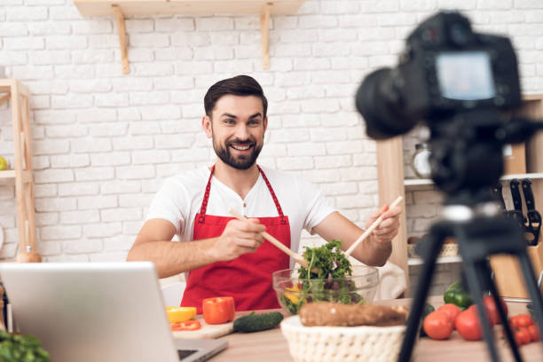 istock Chef presenting food ingredients for culinary podcst viewers. Vegetables and kitchen utensils. 913066064