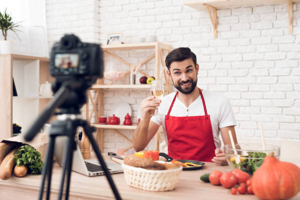 istock Chef tasting wine for culinary podcast shooting. Vegetables and kitchen utensils. 913066138