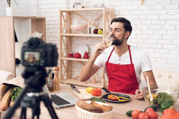 istock Chef tasting wine for culinary podcast shooting. Vegetables and kitchen utensils. 913066140