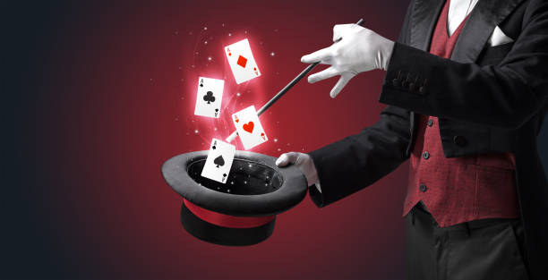 Magician making trick with wand and playing cards