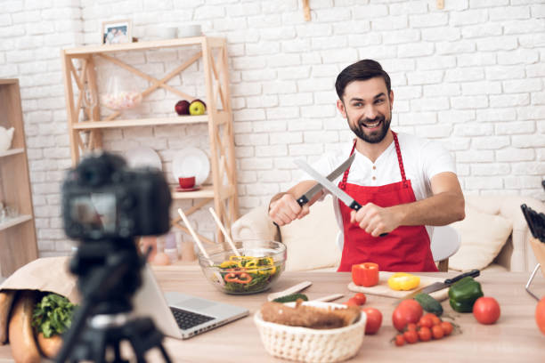 istock Chef showing knives for culinary podcast shooting. Vegetables and kitchen utensils. 913068514