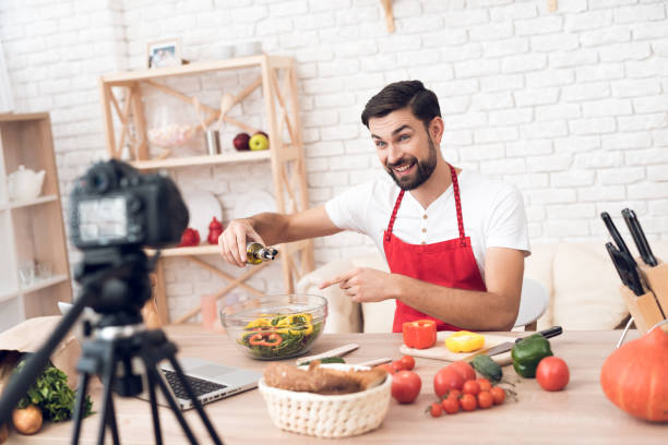istock Chef adding oil in salad for culinary podcast shooting. Vegetables and kitchen utensils. 913068548