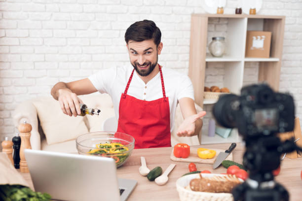 istock Chef adding oil in salad for culinary podcast shooting. Vegetables and kitchen utensils. 913068552