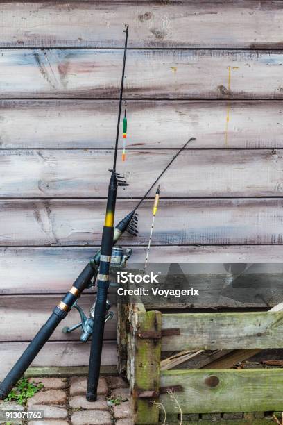 Two Fishing Rods And Wooden Box Standing Outside Stock Photo