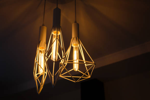 istock Industrial pendant lamps against rough wall loft interior edison bulbs 913072270