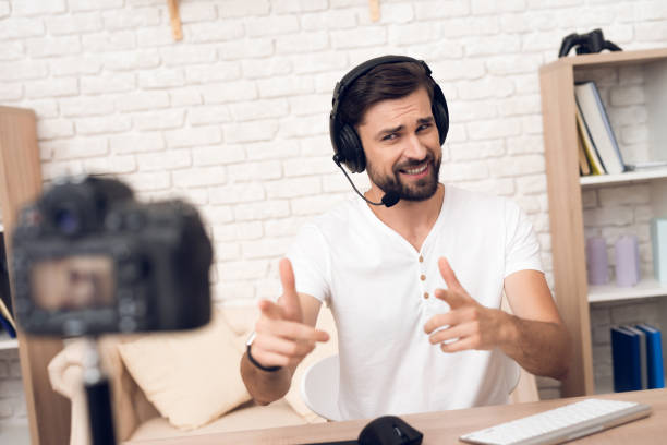 istock Camera shoots man podcaster posing for radio podcast. 913078386