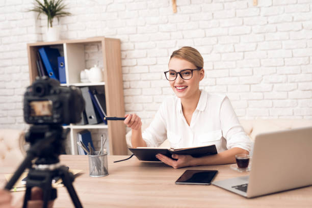 istock Businesswoman reads notes from notebook for business podcast. 913078406