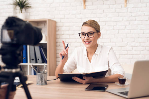 istock Businesswoman reads notes from notebook for business podcast. 913078430