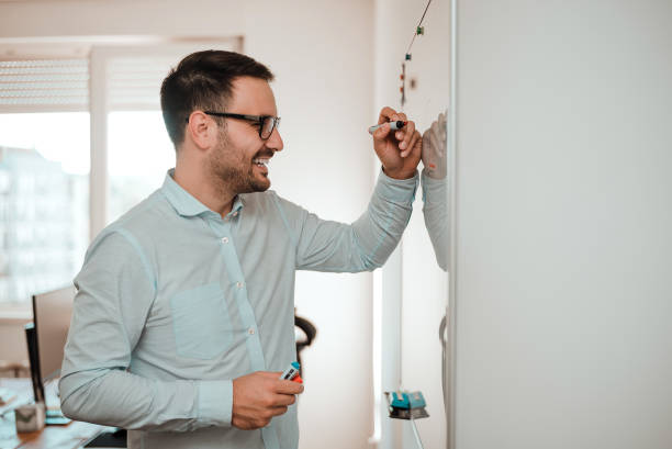 istock Businessman in the office writing notes on whiteboard. 913078634