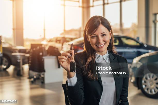 Cheerful Young Woman Showing Her New Car Key At Dealership Stock Photo - Download Image Now