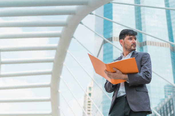 istock Handsome business man holding document. Concept of business work thinking. 913079378