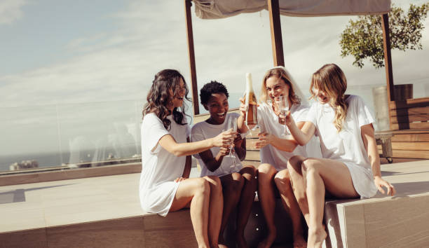 Bachelorette party on rooftop Happy young women drinking champagne at bachelorette party on rooftop. Bride and bridesmaid having fun at hen party. bachelorette party stock pictures, royalty-free photos & images