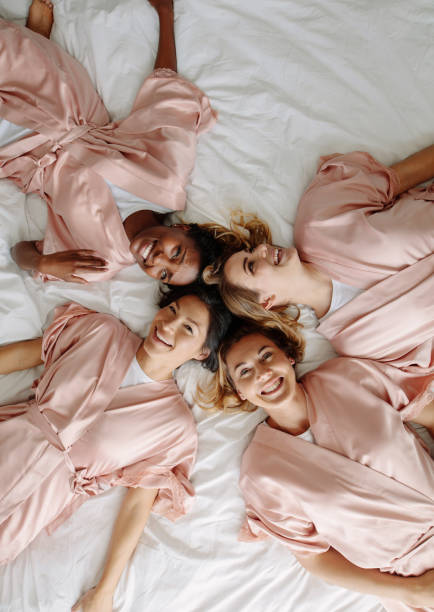 istock Bride with bridesmaids lying on bed and smiling 913086838