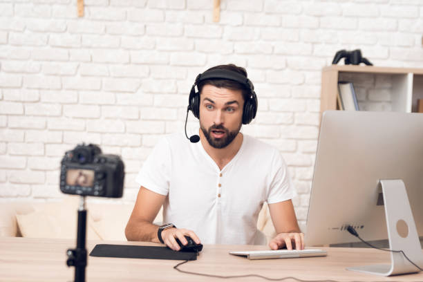 istock Man podcaster posing at camera for radio podcast. 913088040