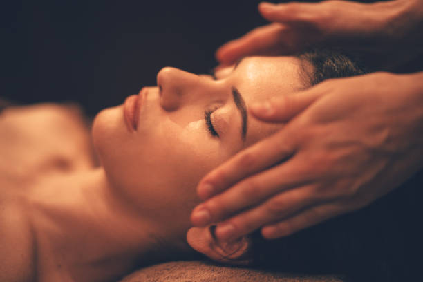Young woman getting head massage at day spa salon Young brunette hispanic woman relaxing and getting facial massage from professional therapist at beauty salon massage oil photos stock pictures, royalty-free photos & images
