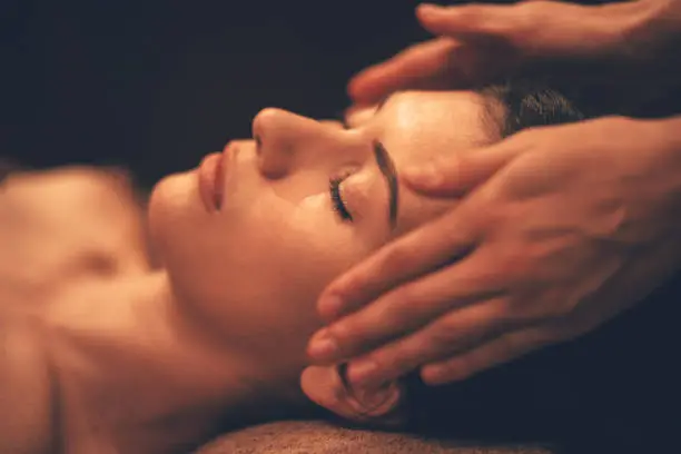 Photo of Young woman getting head massage at day spa salon