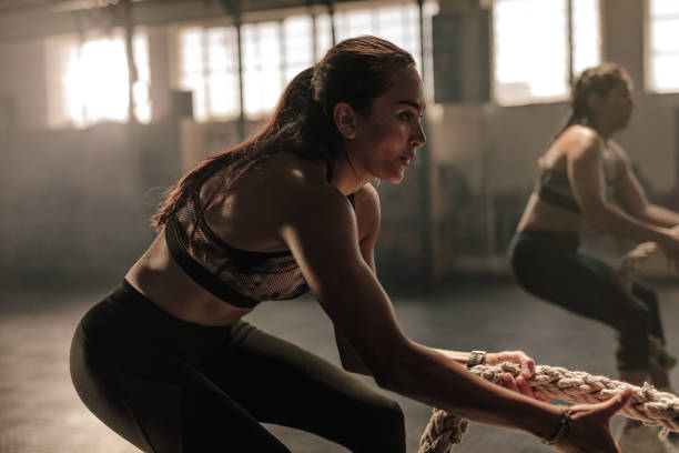 istock Fitness females pulling rope at gym class 913090576