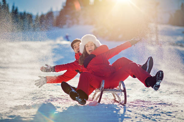 istock Sledding couple is falling on the slope 913091512