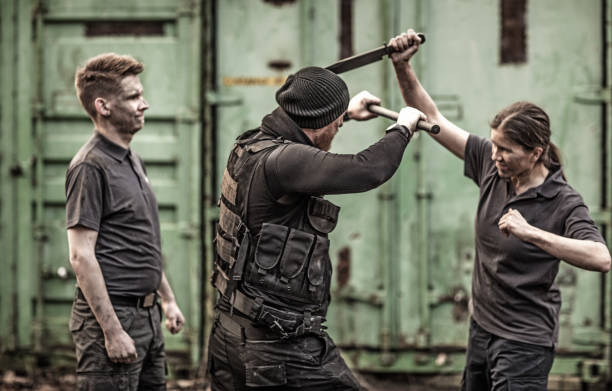 istock Krav Maga fighting instructor leading a training session in grimy outdoor setting 913093920