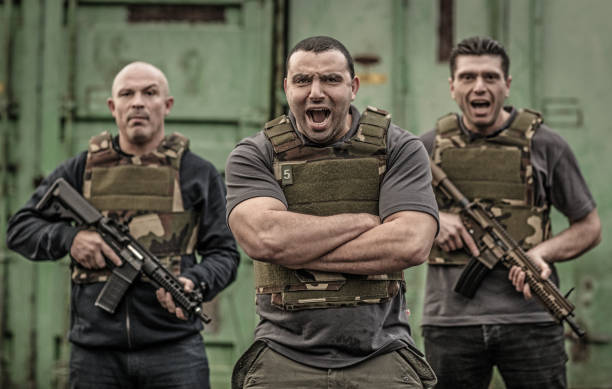 istock Krav Maga fighting group posing for team picture with weapons in grimy outdoor setting 913094164