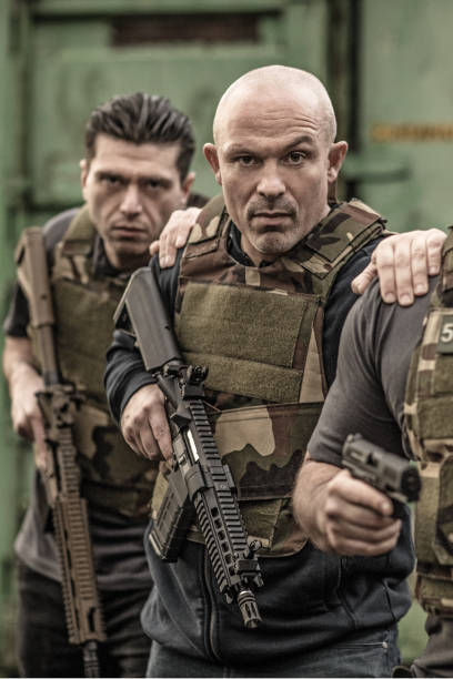 istock Krav Maga fighting group posing for team picture with weapons in grimy outdoor setting 913094324