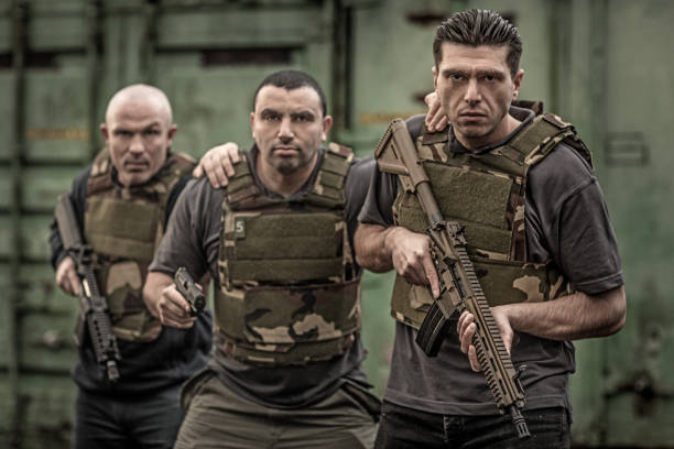 istock Krav Maga fighting group posing for team picture with weapons in grimy outdoor setting 913094326