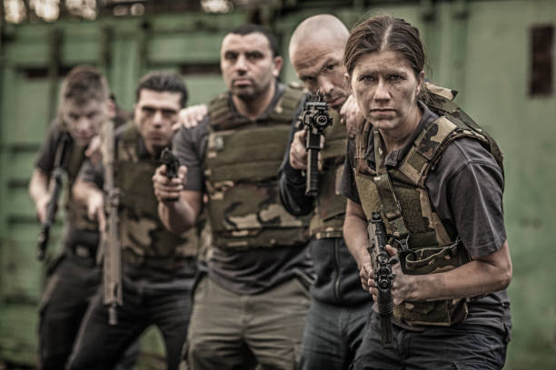 istock Krav Maga fighting group posing for team picture with weapons in grimy outdoor setting 913094430