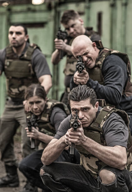 istock Krav Maga fighting group posing for team picture with weapons in grimy outdoor setting 913094436